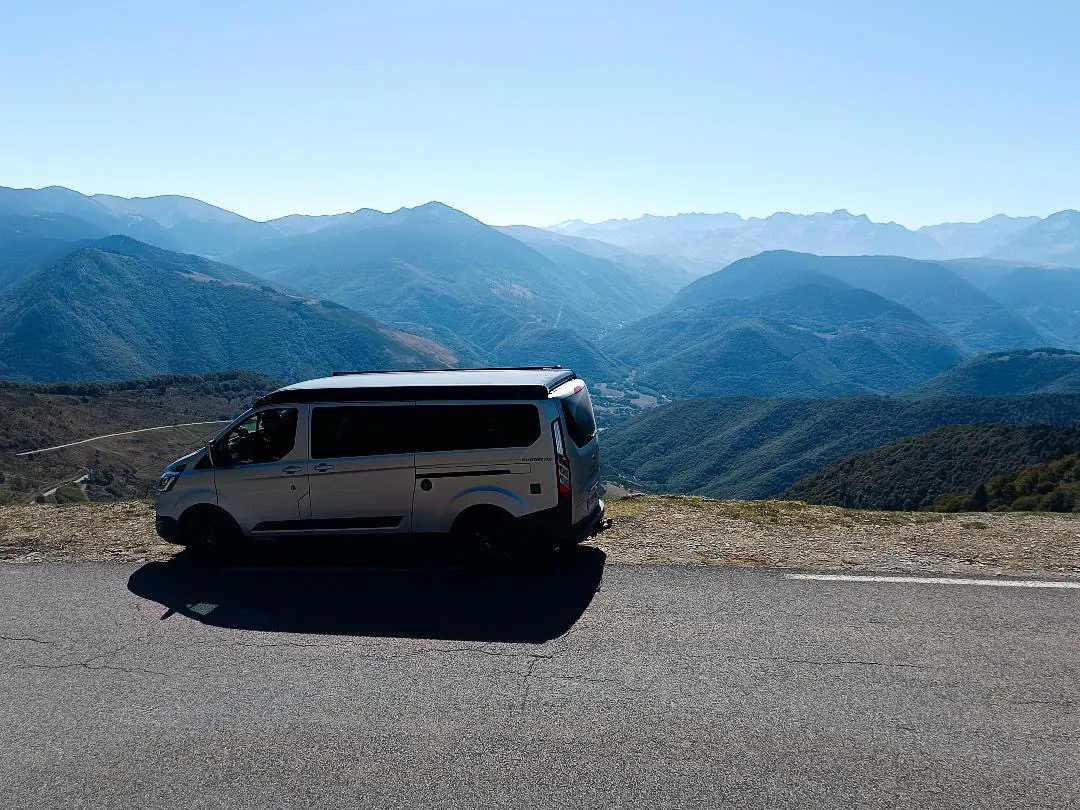 Le van A'Van-ture face à un panorama de vallées superposées dans les montagnes